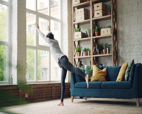 Person doing light stretching in a cozy urban apartment setting